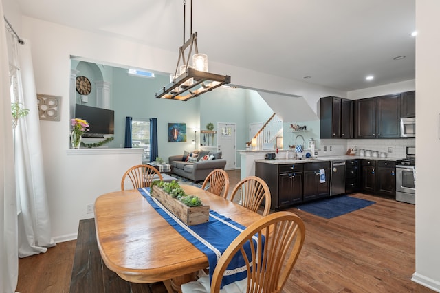 dining space with a chandelier, sink, and dark wood-type flooring