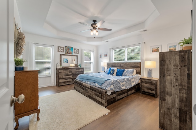 bedroom featuring ceiling fan, a raised ceiling, and hardwood / wood-style floors