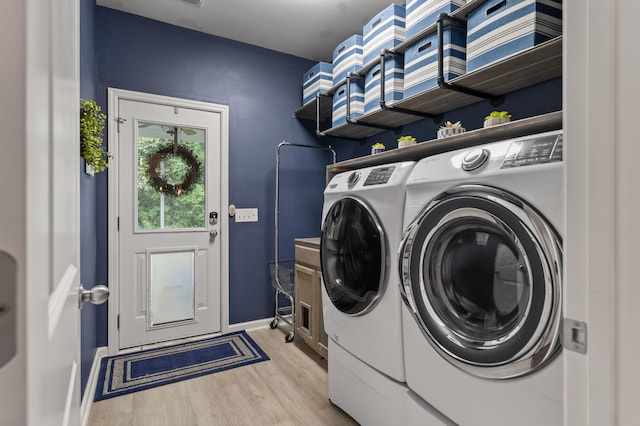 laundry area featuring washer and dryer and light wood-type flooring