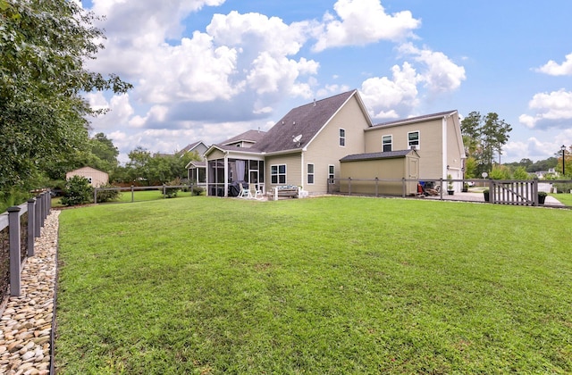 rear view of house with a yard, a patio, and a sunroom