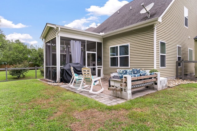 back of house featuring a yard, a patio, and a sunroom