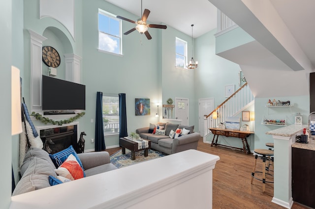 living room with a towering ceiling, a wealth of natural light, and light wood-type flooring