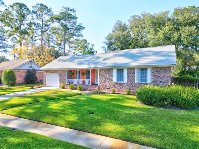 ranch-style home featuring covered porch, a front yard, and a garage