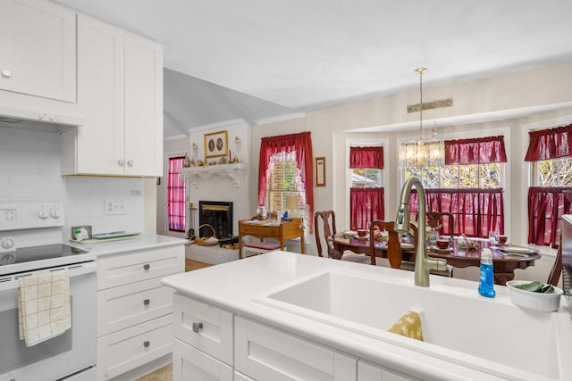 kitchen featuring white cabinetry, white electric stove, sink, and ventilation hood