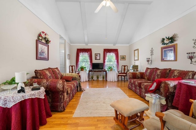 living room with ceiling fan, lofted ceiling with beams, and light wood-type flooring