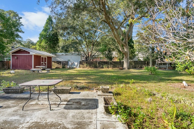 view of yard with a patio area, a storage unit, and a fire pit