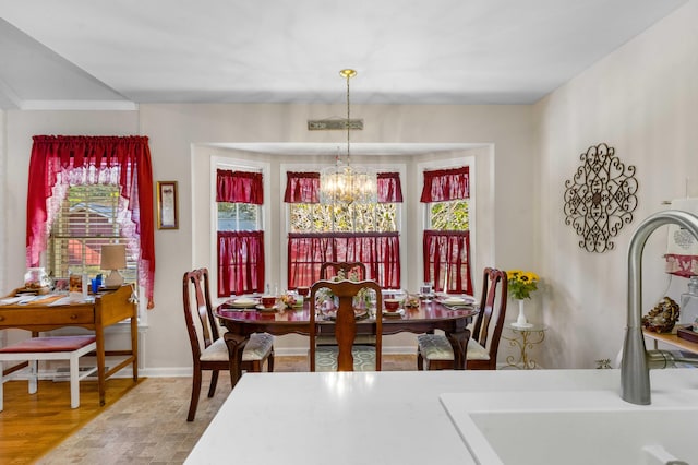 dining room with a notable chandelier, a healthy amount of sunlight, wood-type flooring, and sink