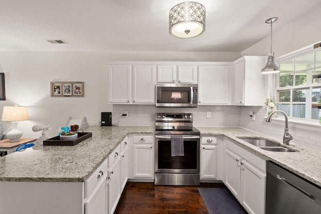 214 Blackstone Dr, Moncks Corner, SC 29461 - kitchen featuring appliances with stainless steel finishes, a sink, a peninsula, white cabinets, and tasteful backsplash