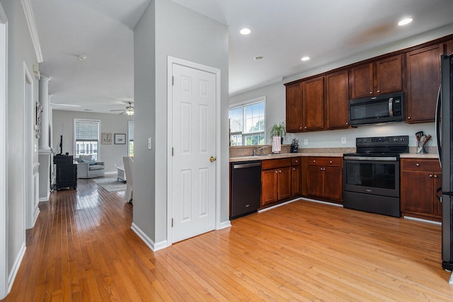 kitchen with light wood-type flooring, black appliances, crown molding, ceiling fan, and sink