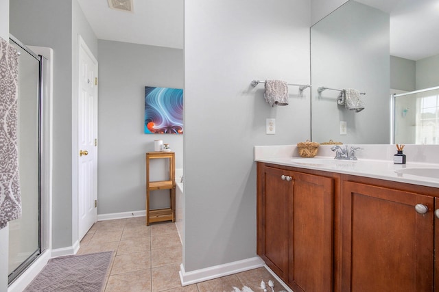 bathroom featuring double vanity, walk in shower, and tile patterned flooring