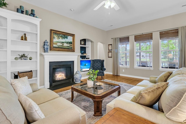1809 Two Cedar Way, Mount Pleasant, SC 29466 - living room featuring arched walkways, a fireplace with flush hearth, wood finished floors, built in shelves, and ceiling fan