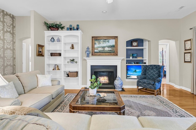 1809 Two Cedar Way, Mount Pleasant, SC 29466 - living area with arched walkways, wood finished floors, a glass covered fireplace, and wallpapered walls