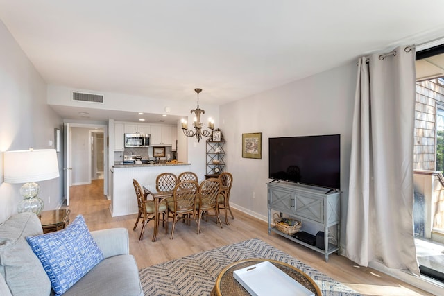 living room with a chandelier and light hardwood / wood-style floors