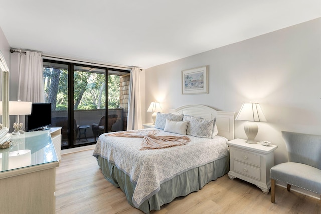 bedroom with access to exterior, light hardwood / wood-style flooring, and floor to ceiling windows