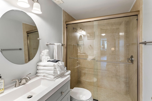 bathroom featuring vanity, toilet, and a shower with door