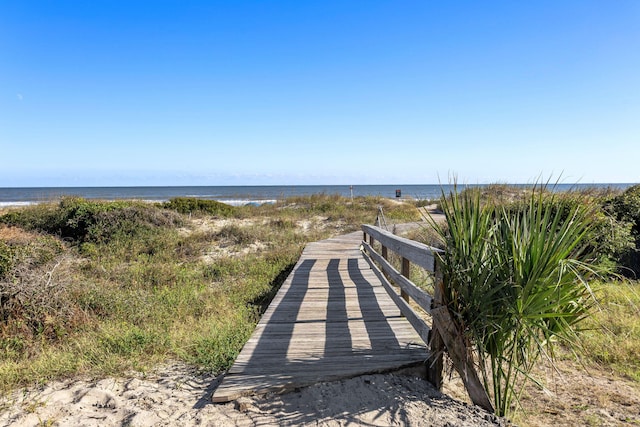 surrounding community featuring a water view and a beach view