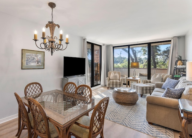 dining area featuring a notable chandelier, floor to ceiling windows, and light hardwood / wood-style floors