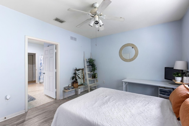 bedroom with baseboards, a ceiling fan, wood finished floors, and visible vents