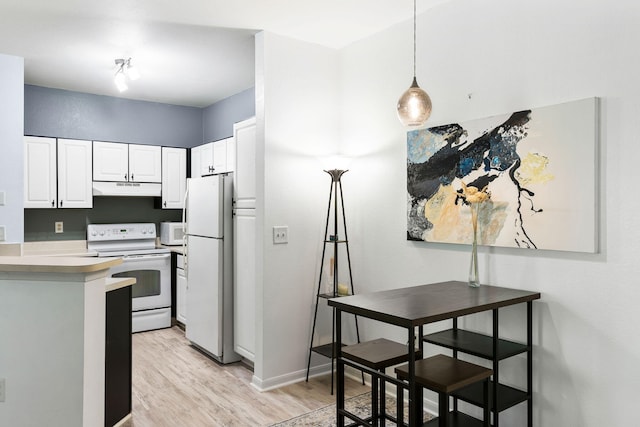 kitchen with white appliances, baseboards, under cabinet range hood, white cabinets, and light wood-style flooring