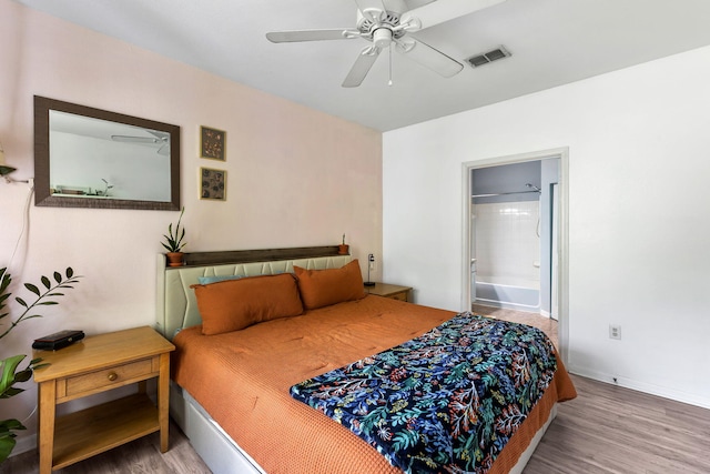 bedroom with baseboards, ensuite bathroom, wood finished floors, and visible vents