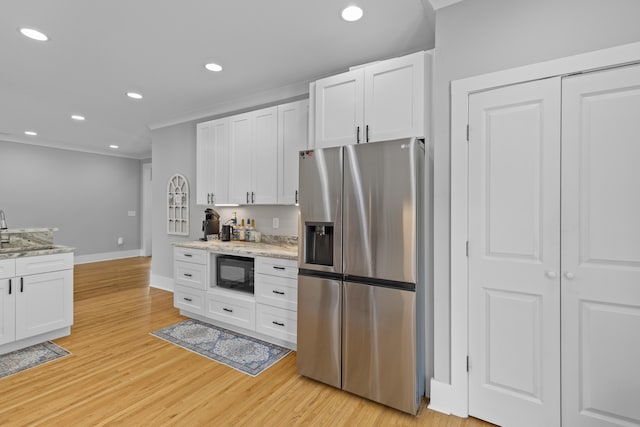 7 Wesley Dr, Charleston, SC 29407 - kitchen with stainless steel fridge, black microwave, white cabinetry, baseboards, and light wood-style flooring
