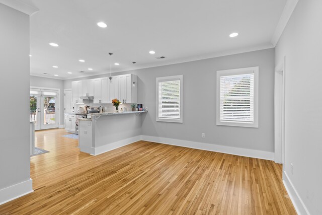 7 Wesley Dr, Charleston, SC 29407 - kitchen featuring ornamental molding, plenty of natural light, light wood finished floors, white cabinets, and french doors