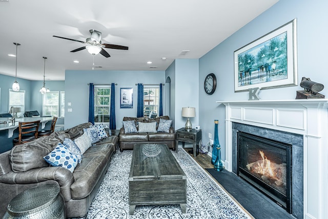 living room with ceiling fan and dark colored carpet