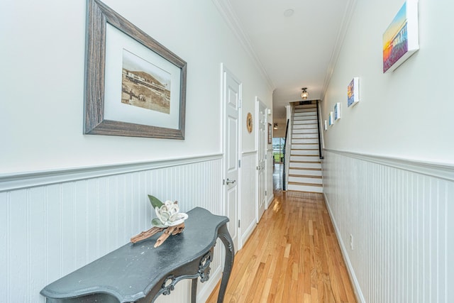 hallway with light hardwood / wood-style floors and crown molding