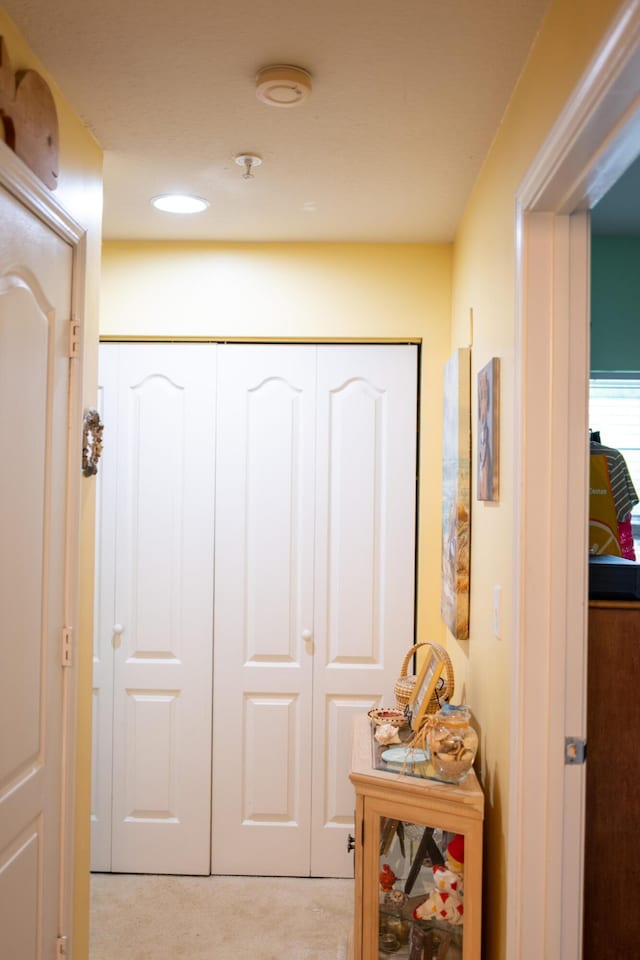 hall with recessed lighting and light carpet