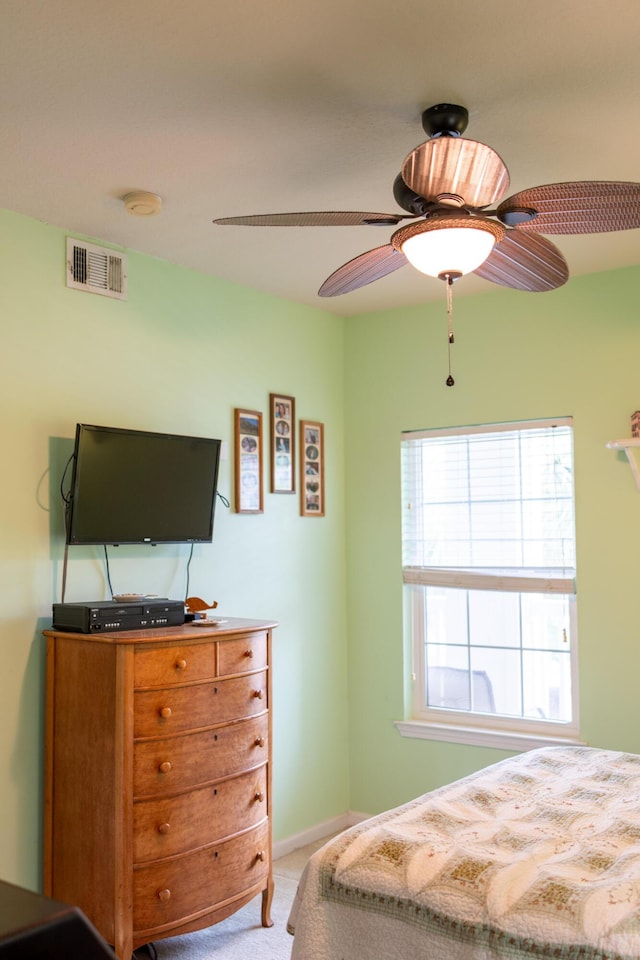 bedroom with light carpet, a ceiling fan, and visible vents