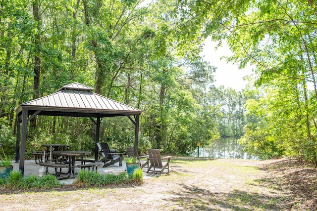 view of community with a water view, a gazebo, a forest view, and a patio area