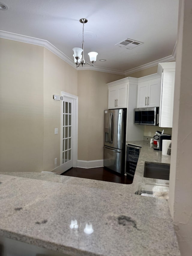 kitchen with visible vents, crown molding, appliances with stainless steel finishes, a notable chandelier, and white cabinetry