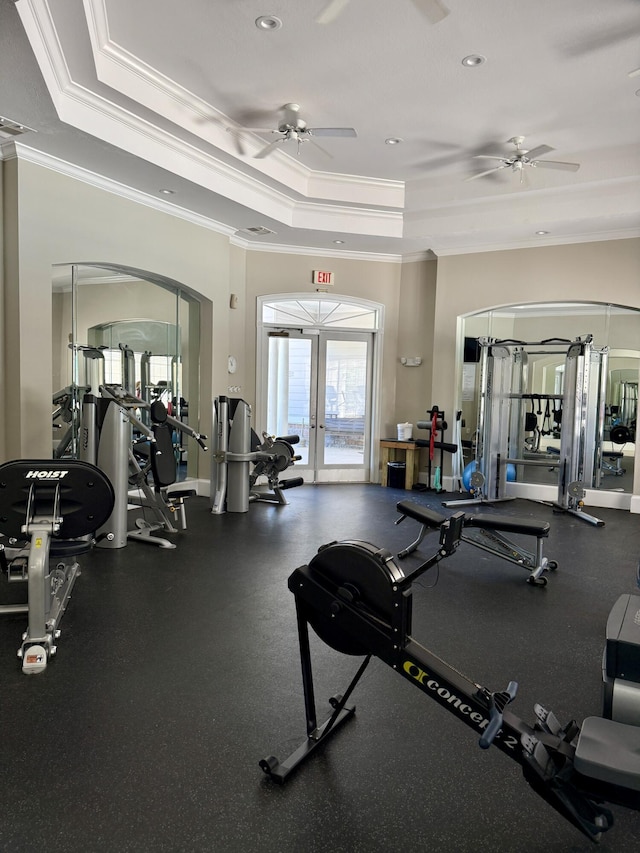 gym with crown molding, visible vents, ceiling fan, a raised ceiling, and arched walkways