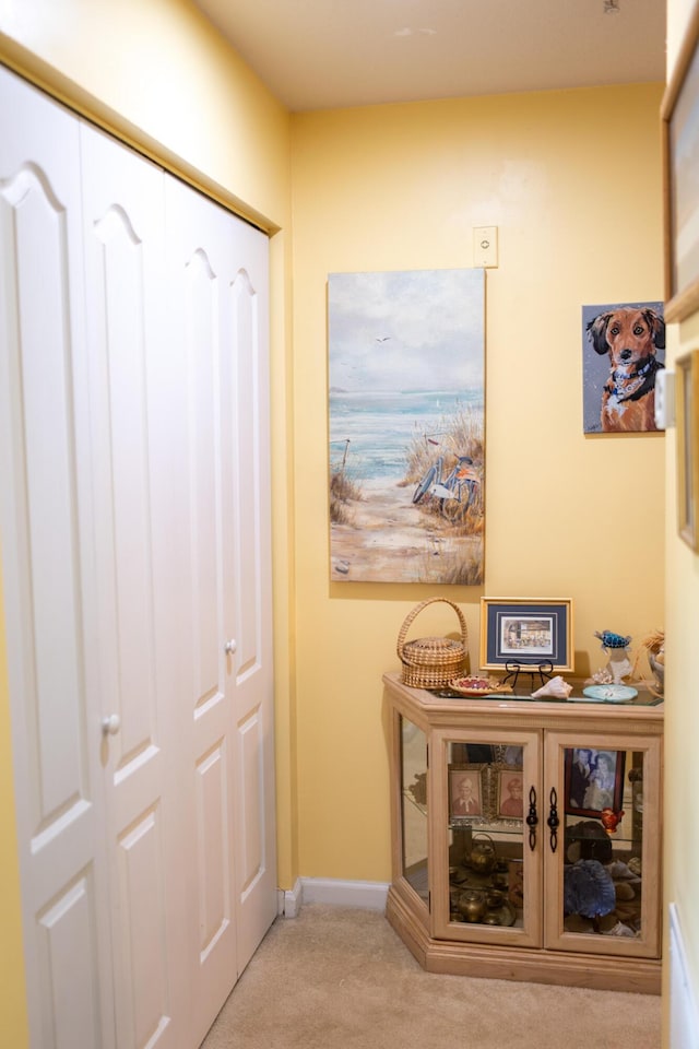 hallway featuring carpet floors and baseboards