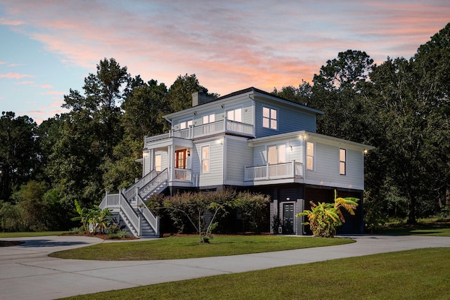 view of front facade featuring a carport, a yard, and a balcony