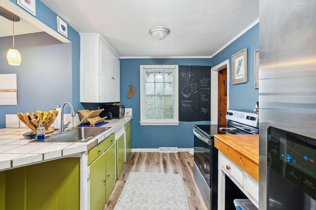 kitchen featuring sink, decorative light fixtures, stainless steel appliances, tile countertops, and light hardwood / wood-style floors