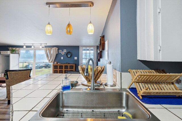 kitchen with hanging light fixtures, tile counters, and sink