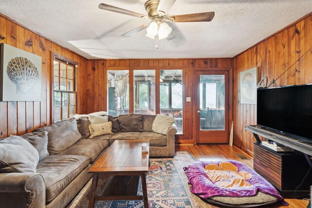 living room featuring ceiling fan, light wood-type flooring, and plenty of natural light