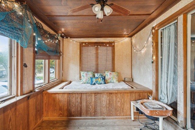 sunroom with ceiling fan and wooden ceiling