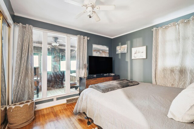 bedroom with ornamental molding, hardwood / wood-style floors, multiple windows, and ceiling fan