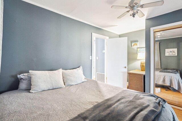 bedroom with ornamental molding, wood-type flooring, and ceiling fan