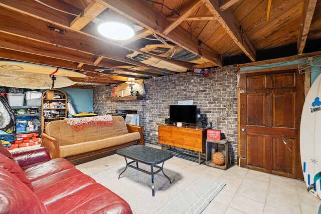 tiled living room with a brick fireplace and brick wall