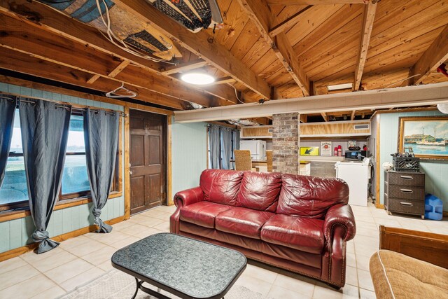 living room with washer and clothes dryer, beamed ceiling, wooden ceiling, and light tile patterned flooring