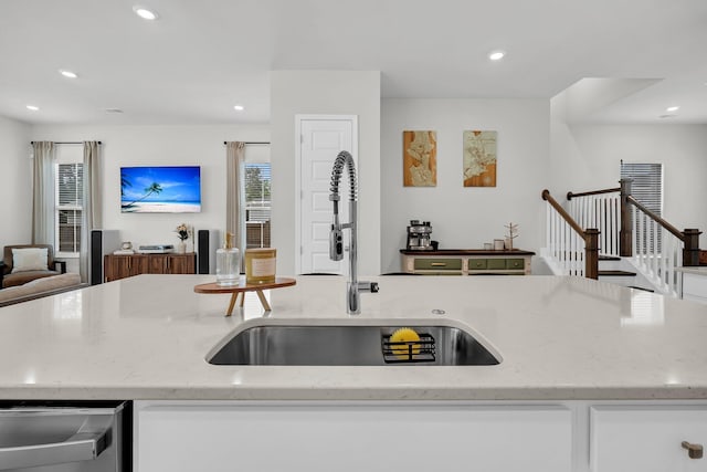 kitchen featuring light stone countertops, a sink, dishwasher, recessed lighting, and open floor plan