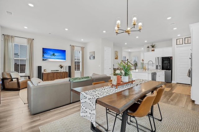 dining space with visible vents, recessed lighting, an inviting chandelier, and light wood-type flooring