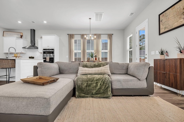 living room with recessed lighting, a notable chandelier, wood finished floors, and visible vents