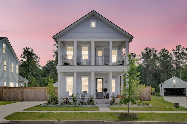 view of front of property with a balcony, fence, covered porch, and a front yard
