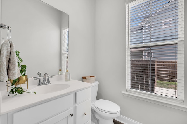 bathroom with vanity, baseboards, and toilet