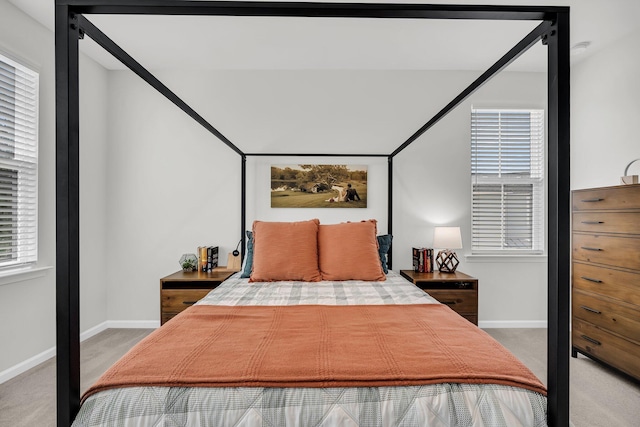 carpeted bedroom with baseboards and multiple windows