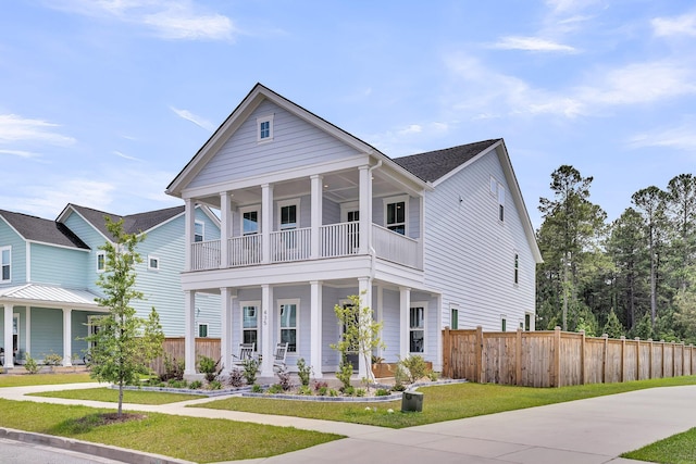 view of front of home featuring fence, a front yard, a porch, and a balcony